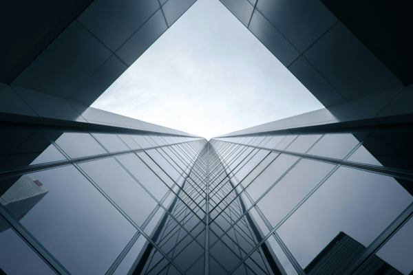 Futuristic high-rise mirror facade with reflective glass surfaces, captured from a low-angle perspective.