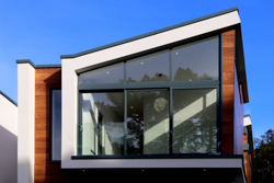 Modern residential house with a large glass front and solar protection films for heat protection.